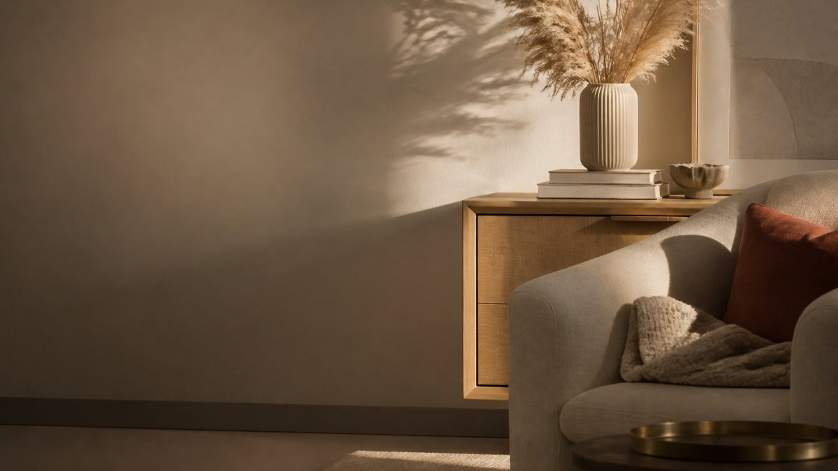 Sunlit living room with an oak sideboard, ceramic vase and linen armchair